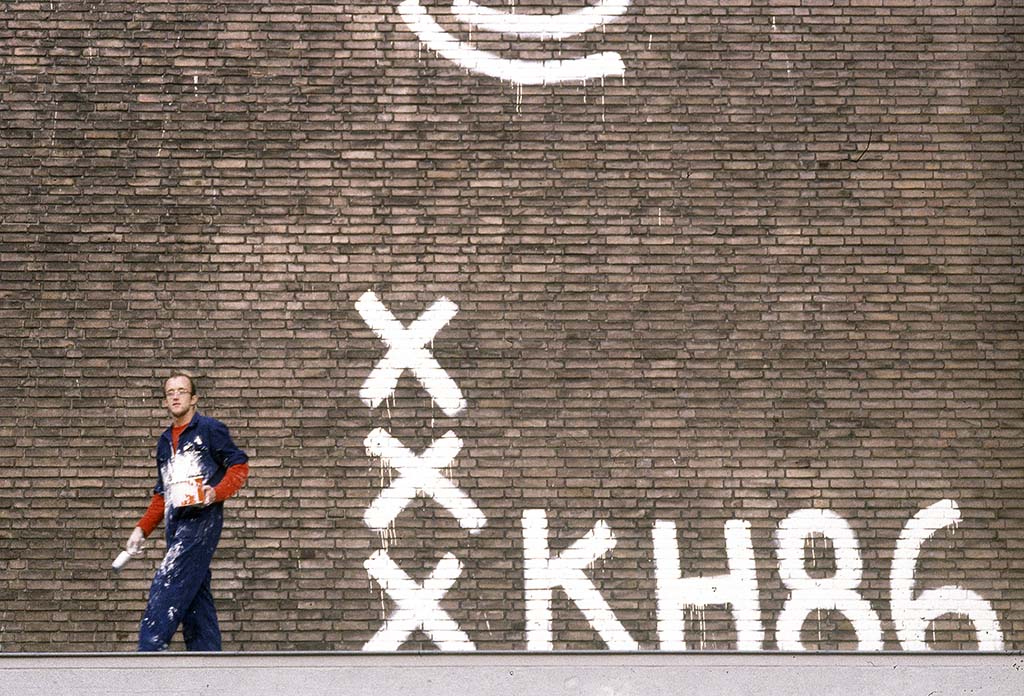 Keith_Haring_at-work-Amsterdam_muurschildering-depot-Stedelijk-1986-©-foto-Patricia-Steur