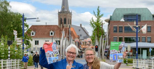 Wilma Lankhorst (links) en Saskia Bruil (rechts) tonen enthousiast de blow ups van de twee stadswandelingen door Doetinchem © foto Jeroen Peters
